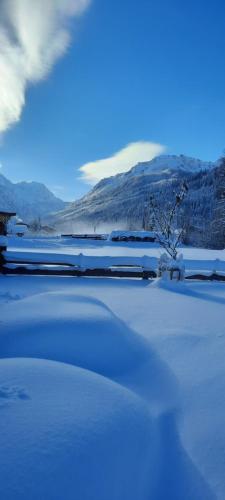a snow covered yard with mountains in the background at Saghäusl in Mitterkleinarl