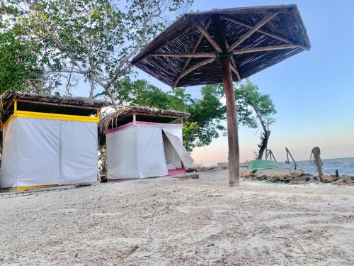 Tintipan IslandにあるArena Beachの海のそばの砂浜の傘