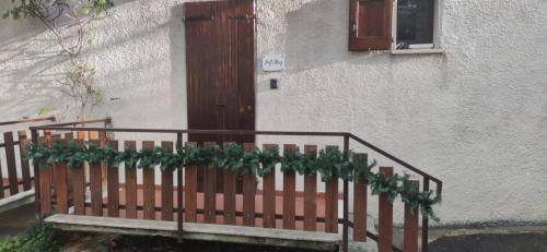 a wooden gate with christmas greenery on it next to a door at Loft Mag in Fanano