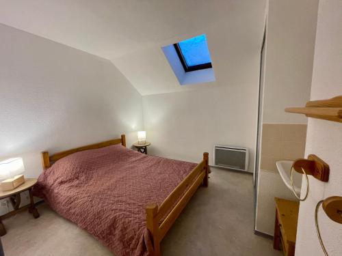 a bedroom with a bed and a skylight at Appartement duplex T2 2 à 5 pers in Villard-de-Lans