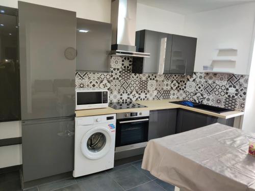 une cuisine avec un lave-linge et un lave-linge dans l'établissement Appartement en centre ville, à Thonon-les-Bains
