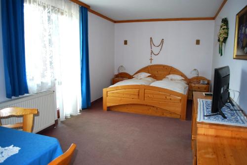 a bedroom with a wooden bed and a television at Angerhof in Dorfstetten