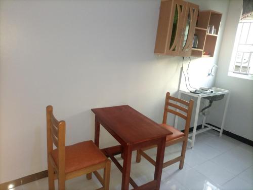 a small table and two chairs in a room at Pearl Motel Buloba in Buloba