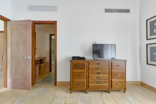 um quarto com uma cómoda em madeira e uma televisão em Majestuosa villa en Juan Dolio, Guavaberry Golf & Country Club em Juan Dolio