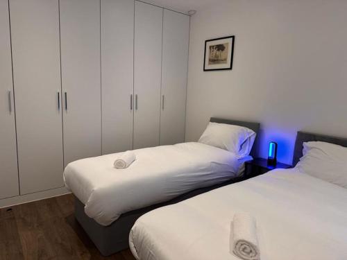 1 Schlafzimmer mit 2 Betten und blauem Licht in der Unterkunft Farringdon Apartments in London