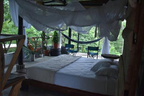 加爾松鎮的住宿－Portal del Sol，一间卧室配有一张天蓬床和两把椅子