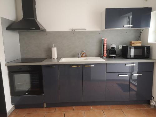 a kitchen with a sink and a microwave at Maison à 500 m du lac in Ardres