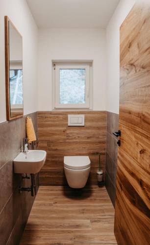 a bathroom with a toilet and a sink and a window at Ferienwohnung Sabine in Flattach