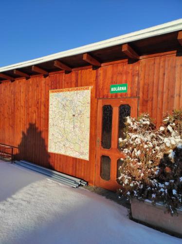 a wooden building with a sign on the side of it at Penzion Kosky in Hamr