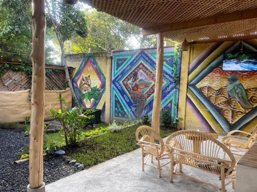 a patio with two chairs and a wall with graffiti at Casa Josep H'i in Sololá