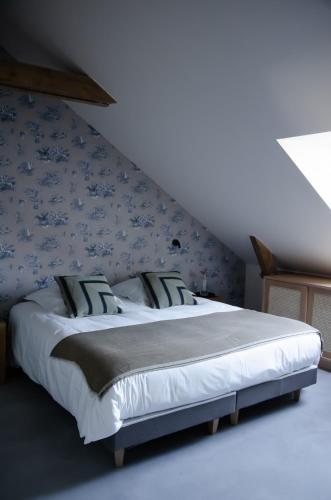 a bedroom with a large bed with blue wallpaper at DOMAINE LE MEZO in Ploeren
