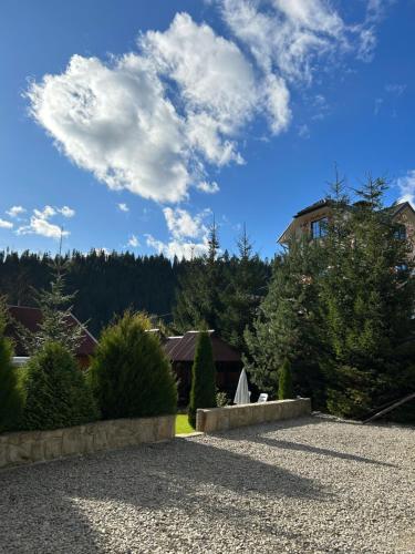 una casa con un cielo azul y nubes en Guest House Kaspiy en Bukovel