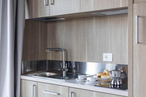 a kitchen with a sink and some bread on the counter at Tuscasì Aparthotel in Sovicille