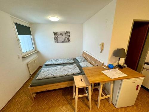 Habitación pequeña con cama y escritorio. en Charmantes Studio im Zentrum, en Dornbirn