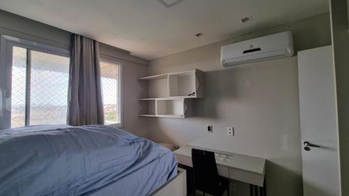 1 dormitorio con cama, escritorio y ventana en Apartamento novo ao lado do shopping da ilha en São Luís
