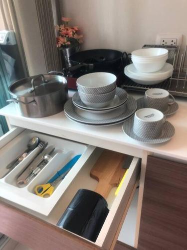 a kitchen shelf with plates and utensils on it at Baan Thewlom in Cha Am