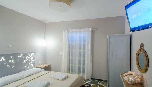 a bedroom with a bed and a flat screen tv at Remvi in Galissas