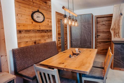 a dining room with a wooden table and a clock at Ferienwohnung Sabine in Flattach