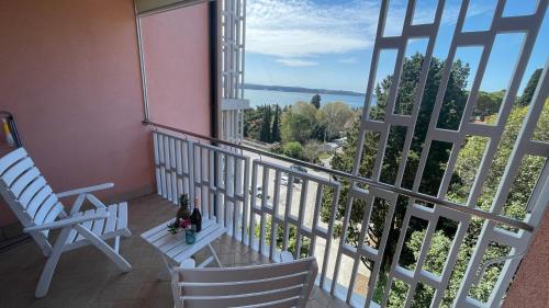 een balkon met 2 stoelen en uitzicht op het water bij Sea & Me, pleasant seaside home in Portorož