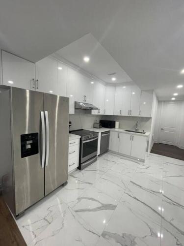 a kitchen with white cabinets and stainless steel appliances at luxury & Spacious 2 bedrooms basement serviced apartment in Brampton