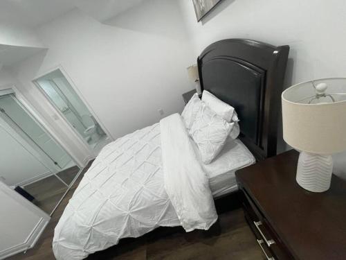 a bedroom with a bed and a table with a lamp at luxury & Spacious 2 bedrooms basement serviced apartment in Brampton