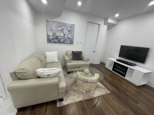 a living room with a couch and a tv at luxury & Spacious 2 bedrooms basement serviced apartment in Brampton