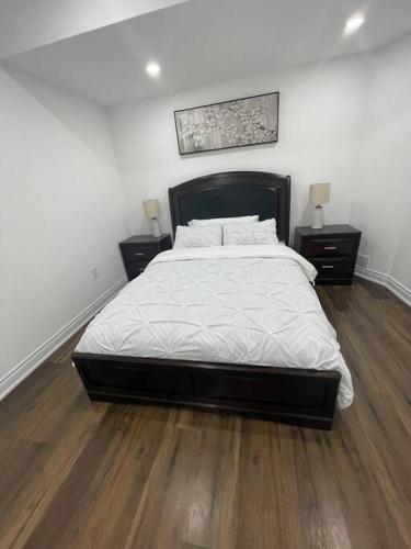 a bedroom with a large bed and two night stands at luxury & Spacious 2 bedrooms basement serviced apartment in Brampton