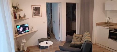 a living room with a couch and a table at L'appentis in Bligny-lès-Beaune