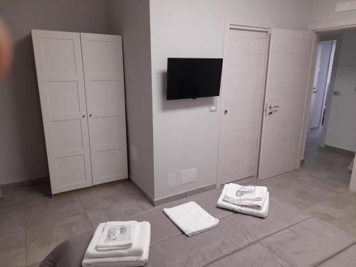 una camera con asciugamani bianchi sul pavimento e TV di MOM'S HOUSE VOMERO a Napoli