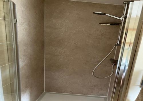 a shower with a glass door in a bathroom at Outlook Cottage in Wandylaw