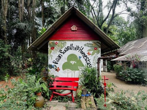 een rode bank buiten een klein huis bij Baan Suanthip Homestay - Aoluek Natural Retreat in Ao Luk