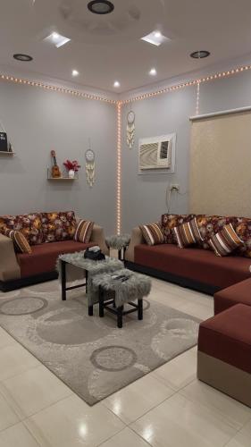 a living room with couches and a table at استراحة وشاليه عزوز in Yanbu