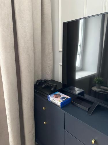 a dresser with a television on top of it at Mariensztat Old Town Apartment in Warsaw