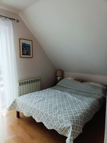 a bedroom with a bed with a blue comforter at Sielski Domek pod Karpaczem in Miłków