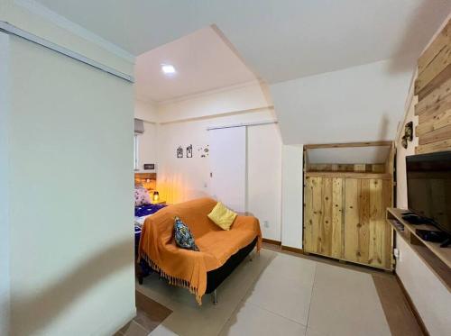 ein Schlafzimmer mit einem Bett mit einer orangefarbenen Decke in der Unterkunft Centro da cidade, Teresópolis. Várzea. in Teresópolis