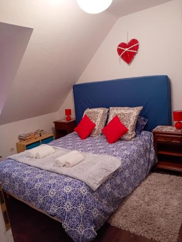 - une chambre avec un lit bleu et des oreillers rouges dans l'établissement Appartement de 2 chambres avec jardin amenage a Ingersheim, à Ingersheim