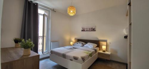 une chambre avec un lit et une grande fenêtre dans l'établissement Résidence du soleil, à Béziers