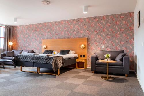una camera con un letto e due divani in una stanza di Milepelen Hotel & Vertshus a Sand