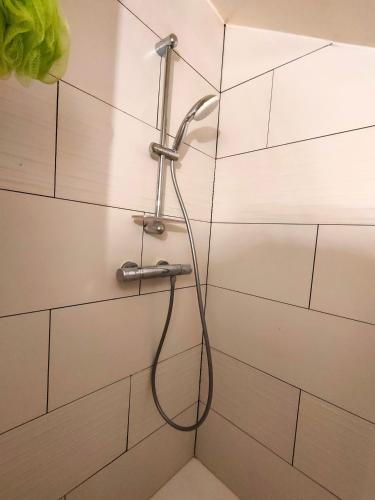 a shower with a hose attached to a wall at Maison de ski et randonnée in Lez