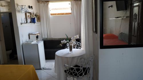 ein Wohnzimmer mit einem Tisch und einem Sofa in der Unterkunft Suítes Maravilha Arraial do Cabo in Arraial do Cabo