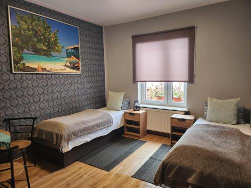 ein kleines Zimmer mit 2 Betten und einem Fenster in der Unterkunft Gościnna Hacjenda in Radwanice