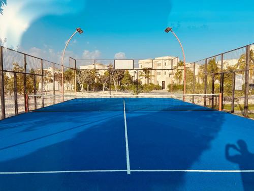 a tennis court with two lights on top of it at 1-Bedroom on Forest Island & Oceanside View in Salalah