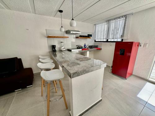 a kitchen with a counter and a red refrigerator at Depa Lunero in Cancún