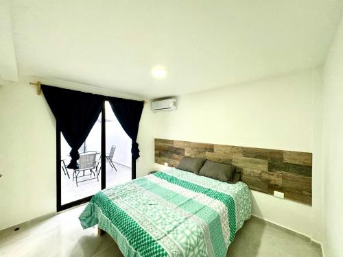 a bedroom with a bed and a large window at Depa Lunero in Cancún