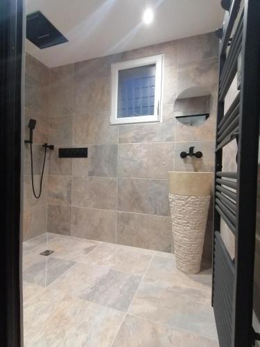 a bathroom with a shower and a window at Gîtes déco pop et chaleureuse avec jacuzzi, sauna, piece coquine in Calais