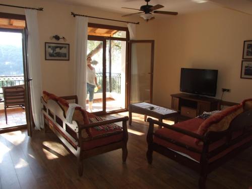 a living room with two chairs and a flat screen tv at Magda's Hotel Apartments in Parga