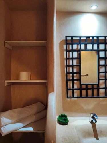 a bathroom with a sink and a mirror at Hôte sahara & spa TADIGHOUST in El Hara