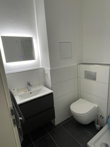La petite salle de bains est pourvue de toilettes et d'un lavabo. dans l'établissement Leipzig City Apartment - Südperle - direkt im Geschehen, à Leipzig