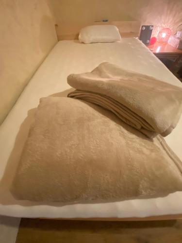 duas almofadas numa cama num quarto em This is OKINAWA em Motobu
