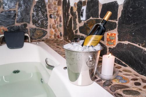 a bottle of wine in a bucket next to a bath tub at Stardome Spiritual Experience in Ollantaytambo